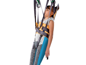 Child supported in a Guldmann Vest for Standing Shell sling during a standing transfer with a ceiling hoist.