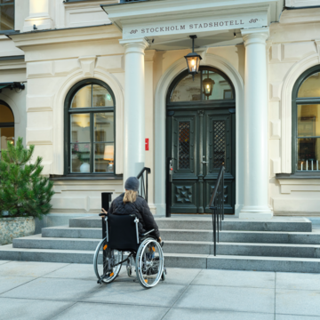 Wheelchair user in front of Stepless SLP Model C platform lift at Stockholm Stadshotell