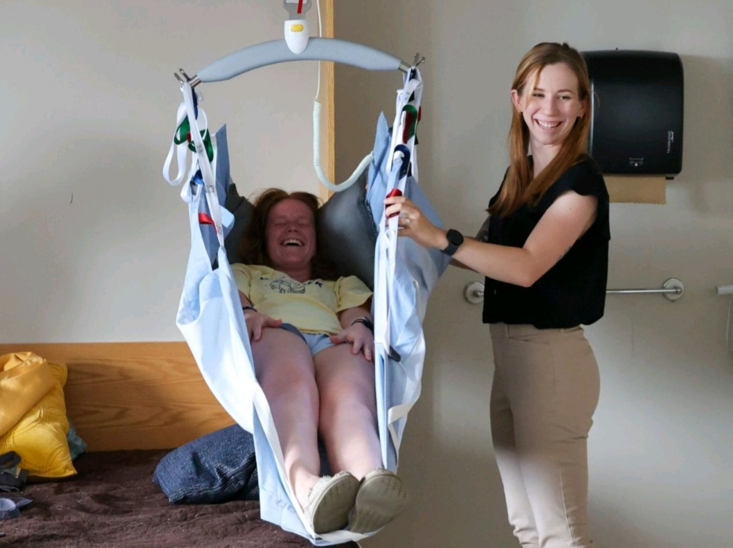 Student practicing safe patient handling in a Guldmann Repositioning Sling during occupational therapy training at Elizabethtown College.